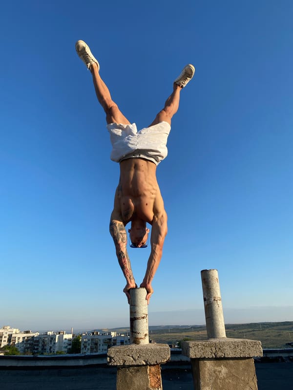 Rooftop handstand on concrete pillars under open sky, Pleven