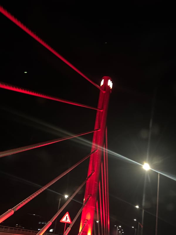 Millennium Bridge glows red in nighttime illumination, Podgorica