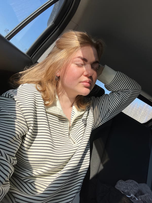 Woman rests in passenger seat during early morning travel