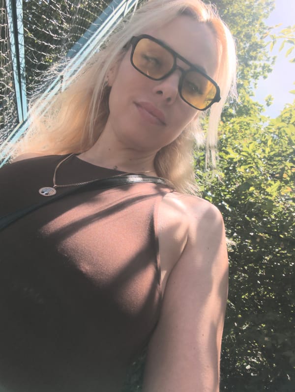 Woman photographs herself and white cat in Sevastopol morning
