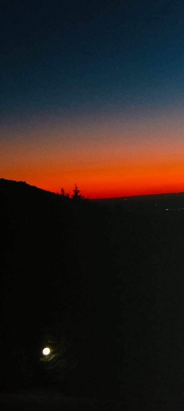 Sunset gradient over La Pinilla's pine-covered hills