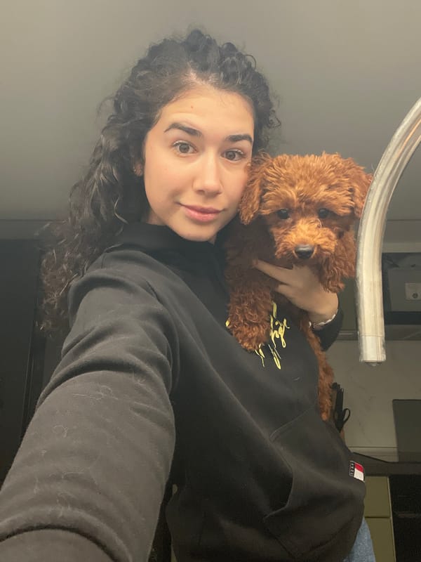 Woman poses with small brown poodle in Sofia apartment