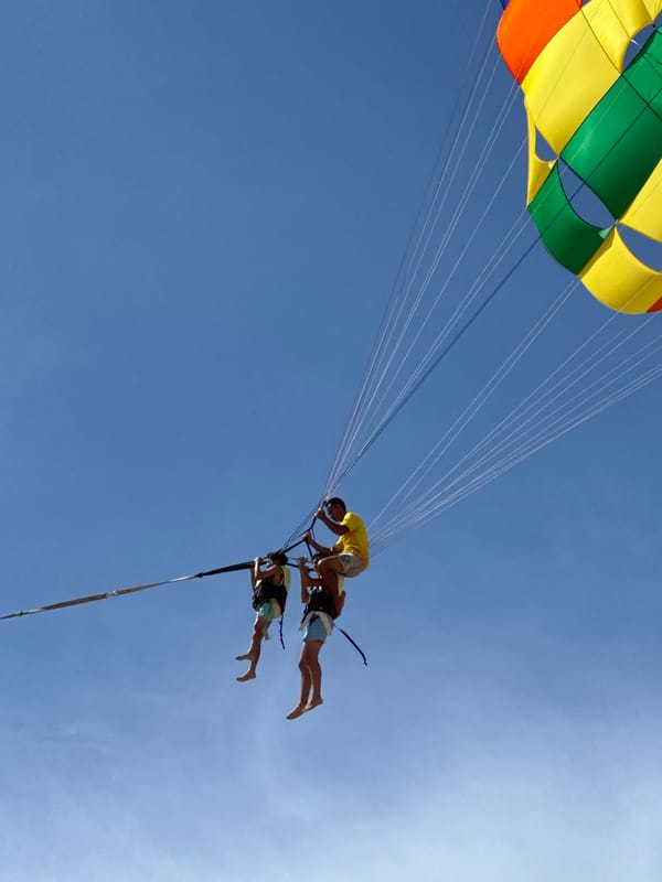 Patong Beach buzzes with parasailing, jet skis, and beachgoers