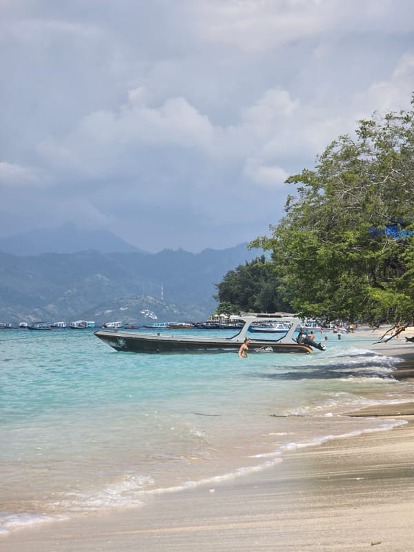 Morning beach scene captured in Indonesia with boats and swimmers