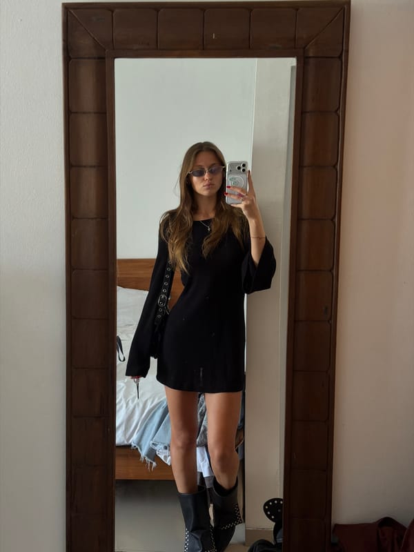 Woman takes mirror selfie in black dress in North Kuta bedroom