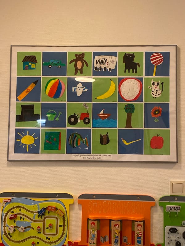 Art display documented in Bälinge featuring children's drawings, watercolors
