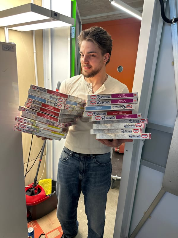 Man holds stack of frozen pizzas in Volketswil