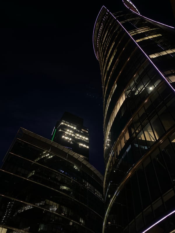 Warsaw's twisting glass towers glow against the night sky