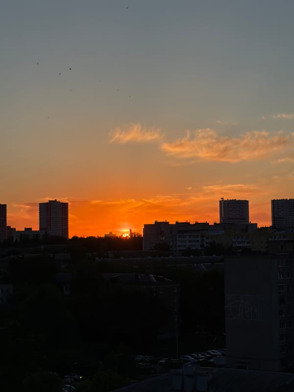 Urban sunset photographed with orange sky behind city buildings