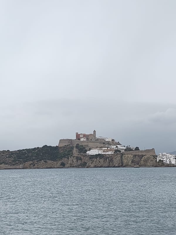 Coastal views of historic Ibiza and docked sailboat captured