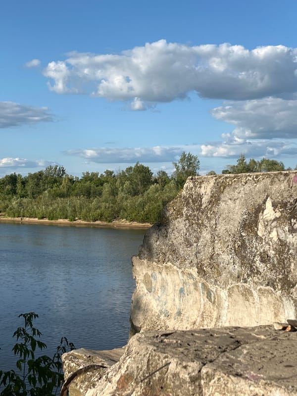 Pripyat riverbank in Narowlya: calm water, weathered Soviet monument