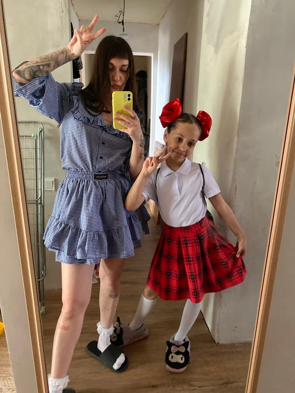 Woman styles young girl's hair during indoor photo session