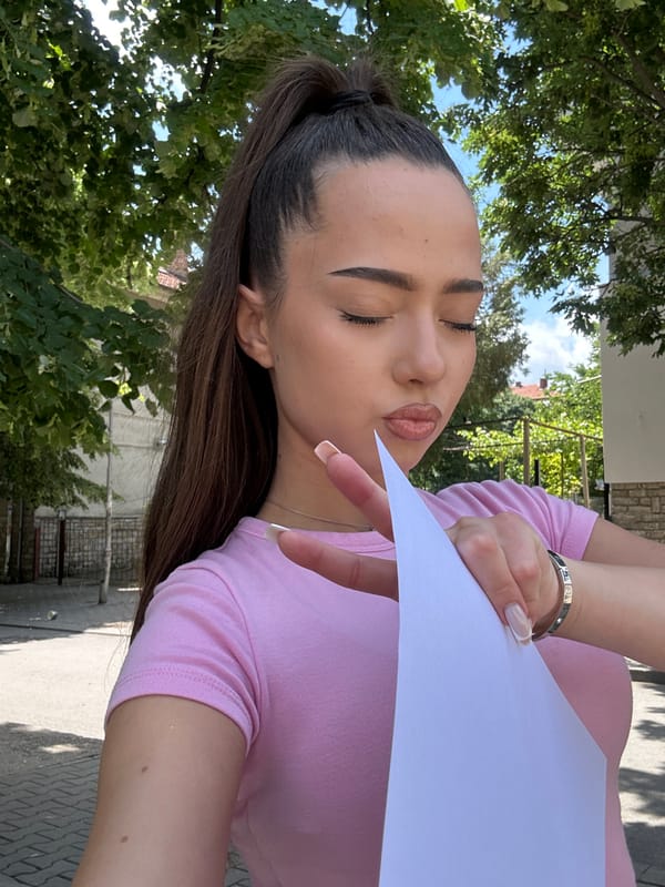 Woman takes outdoor selfies with certificate during brief photo session