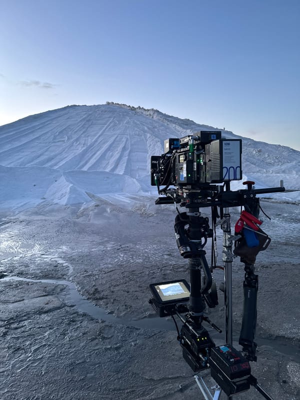 Film crew captures snowy mountain landscape at dawn
