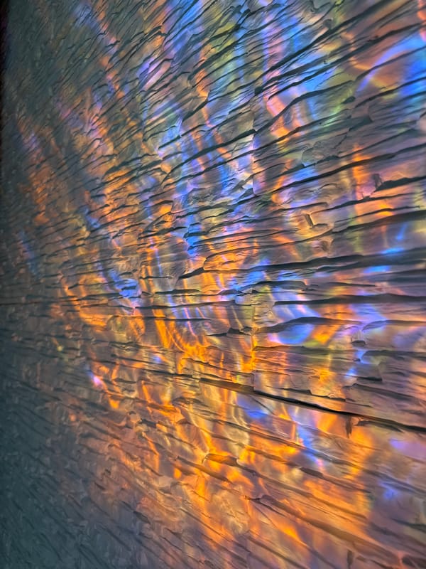 Colorful light show projected onto textured stone wall