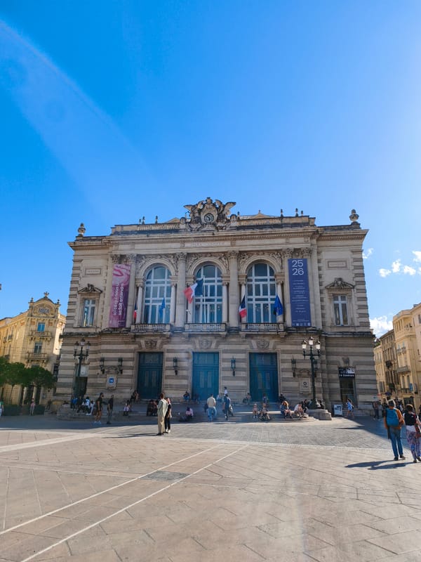 Theater displays French flags from arched windows in Montpellier