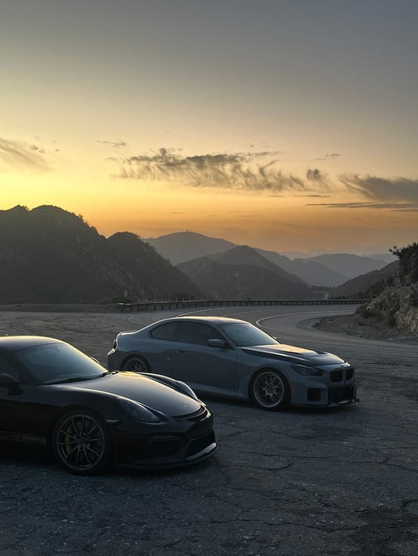 Sports cars gather on Altadena mountain road at sunset
