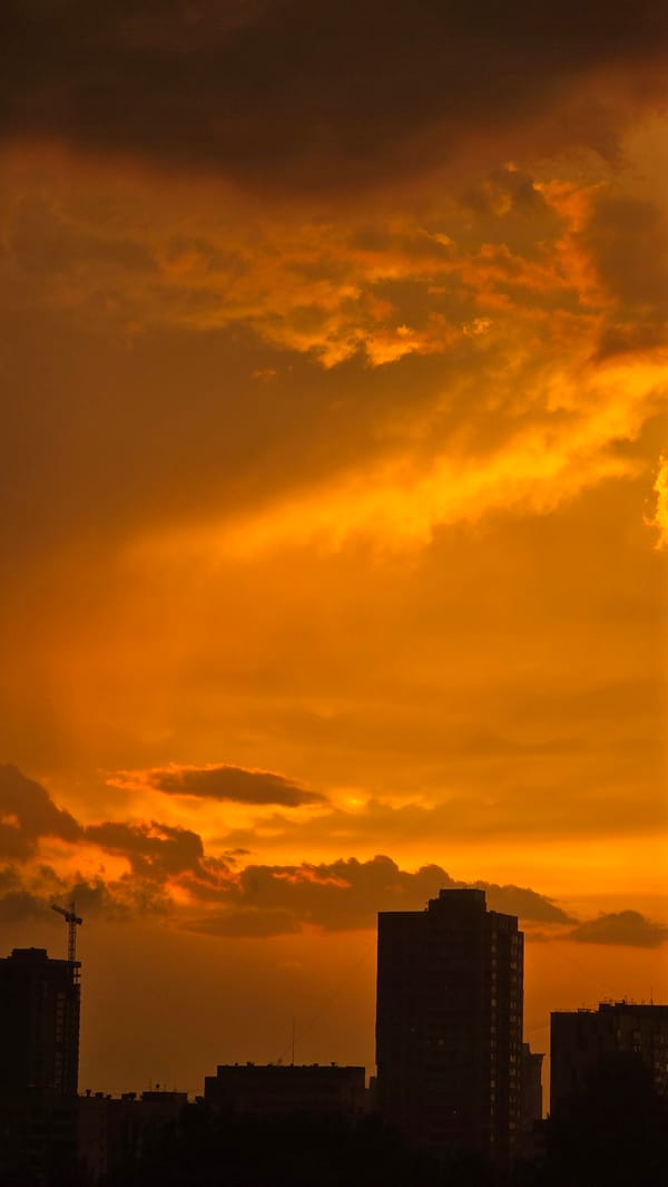 Kyiv apartment skyline glows under a vivid summer sunset