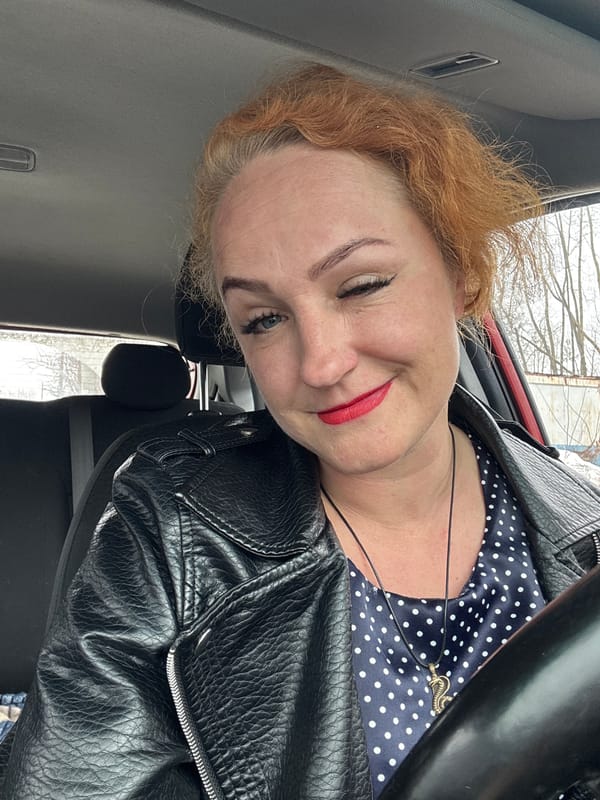 Woman poses playfully in driver's seat, Chaikovsky Russia