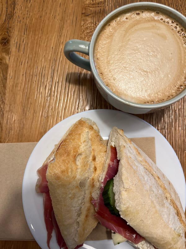 Coffee and sandwich captured on wooden table in Sofia