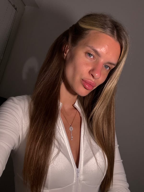 Woman takes selfies in Berlin bathroom wearing white jumpsuit