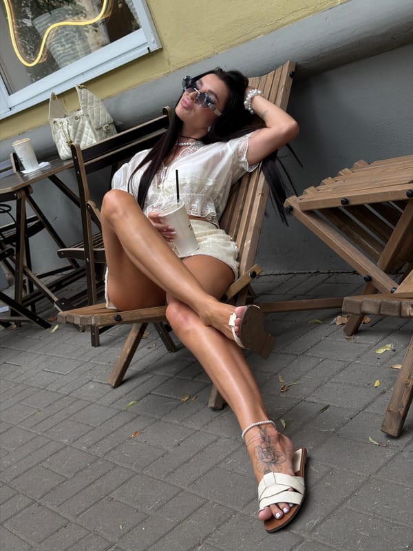 Chilling outdoors with a drink, white outfit, and shades