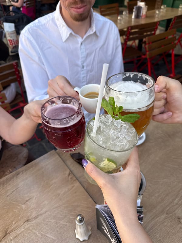 Friends toast with drinks at outdoor table in Budapest
