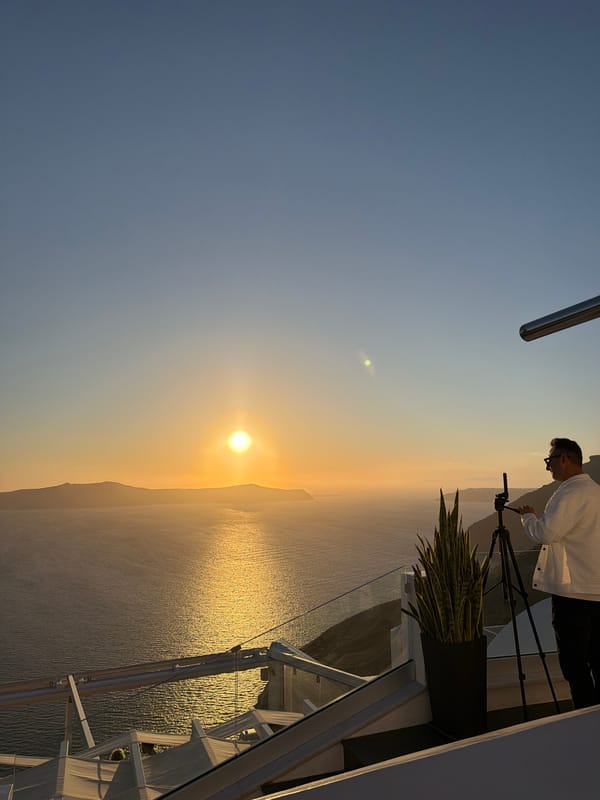 Tourist captures sunset and local shops during Santorini afternoon visit