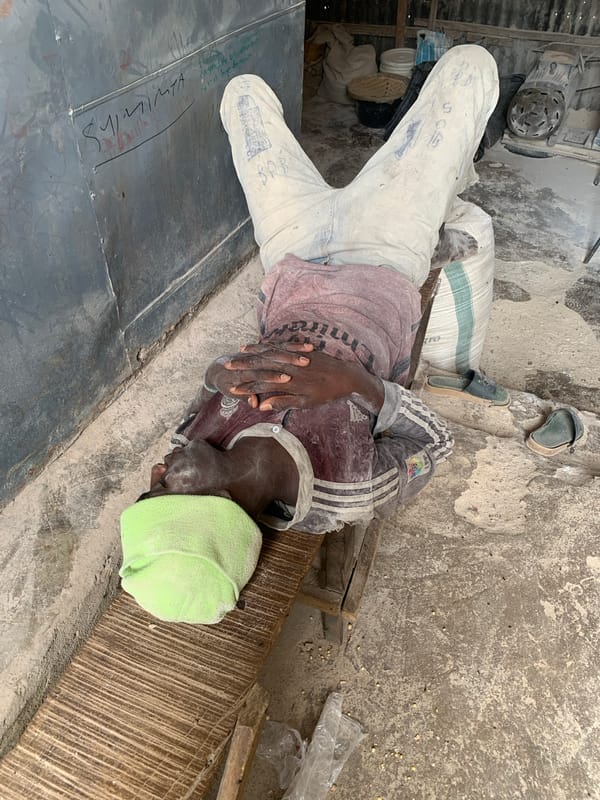 Dust-covered man rests in corrugated metal interior space