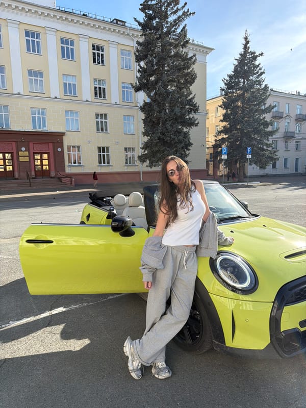 Couple poses with yellow Mini Cooper in Zheleznogorsk