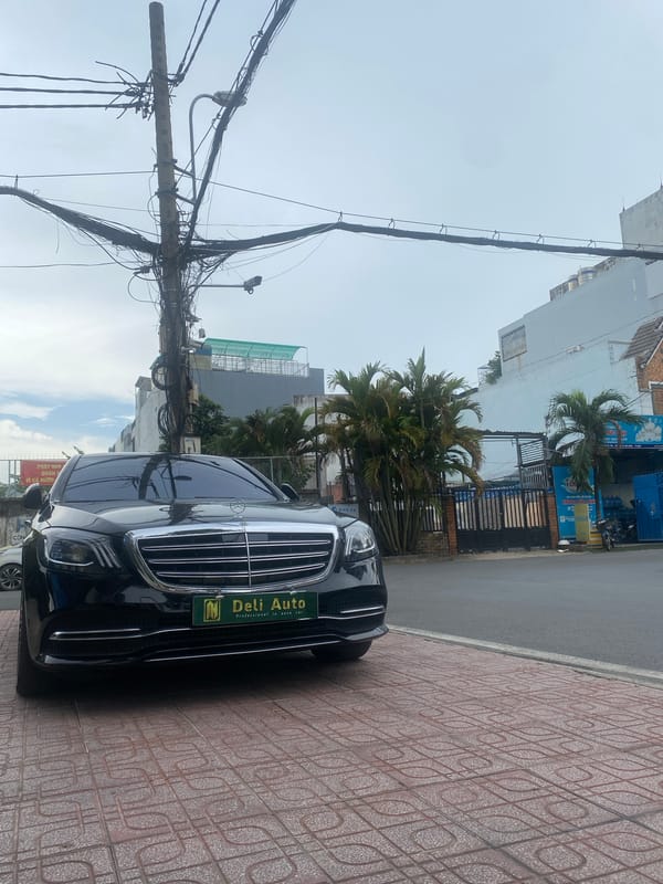 Luxury cars and everyday riders share a Thuận An street