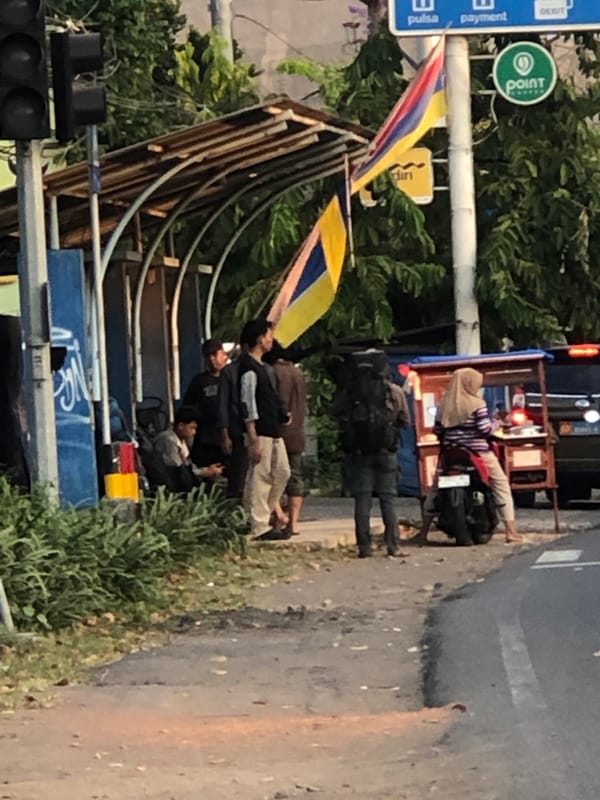 Mixed traffic flows through a commercial street in Kludan, Indonesia