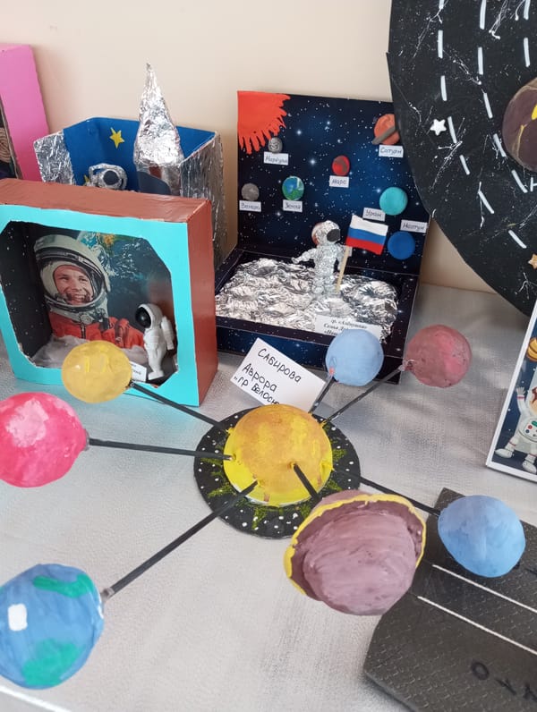Children's space art projects displayed on tabletop