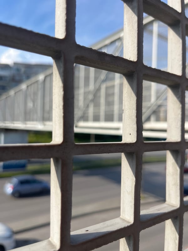 Pedestrian documents urban view through bridge grid in Varna