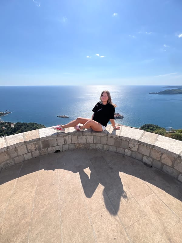 Tourists photograph scenic Adriatic views at Montenegro's Sveti Stefan