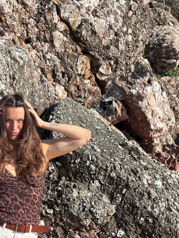 Woman rests on rocks in Sveti Stefan, Montenegro
