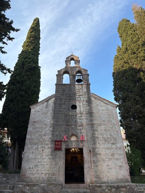 Tourist documents historic church and coastal islet in Montenegro