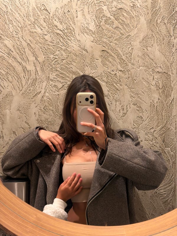 Person takes mirror selfie in Krasnoyarsk room