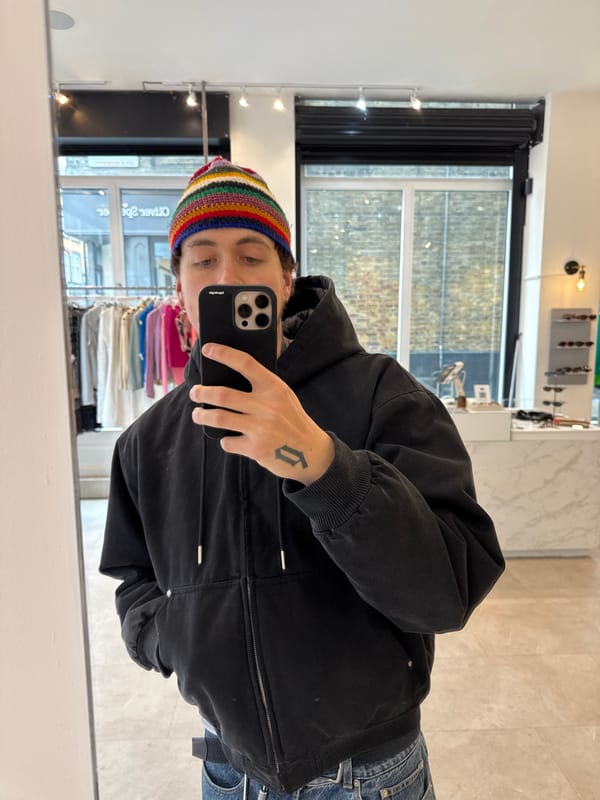 Person takes mirror selfie in London clothing store