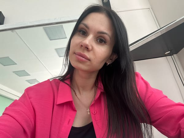 Woman photographed in upside-down selfie wearing pink blazer