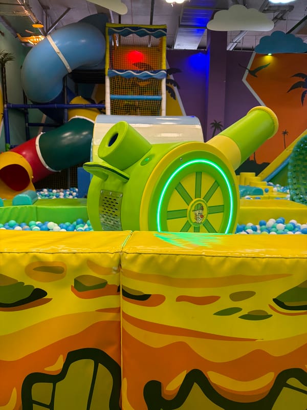 Child enjoys indoor playground with trampolines and inflatable attractions