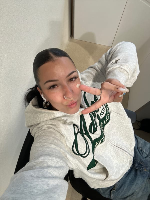 Woman poses for selfies in Paris wearing gray hoodie