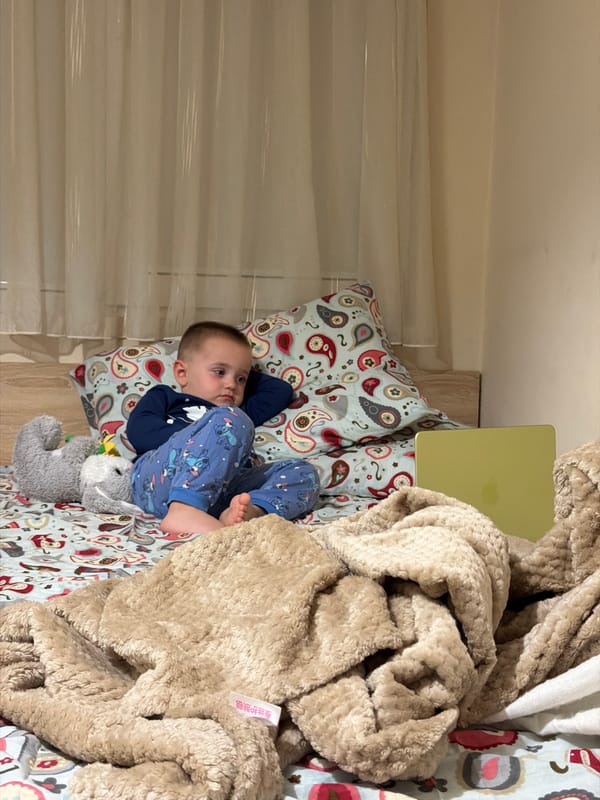 Child rests in blue pajamas with stuffed animal in Pomorie
