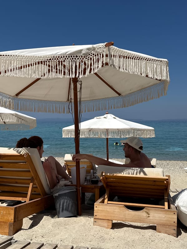 Lazy afternoon on a Greek beach under white fringed umbrellas