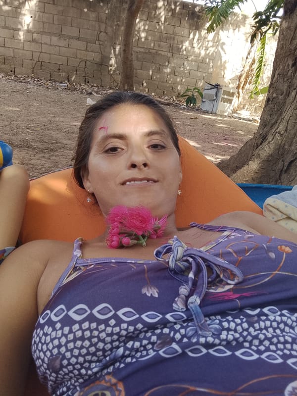 Family relaxes outdoors with flowers in Venezuelan neighborhood