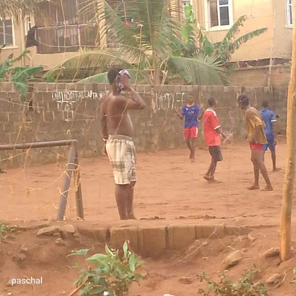 Informal soccer game played on dirt field in Nigeria
