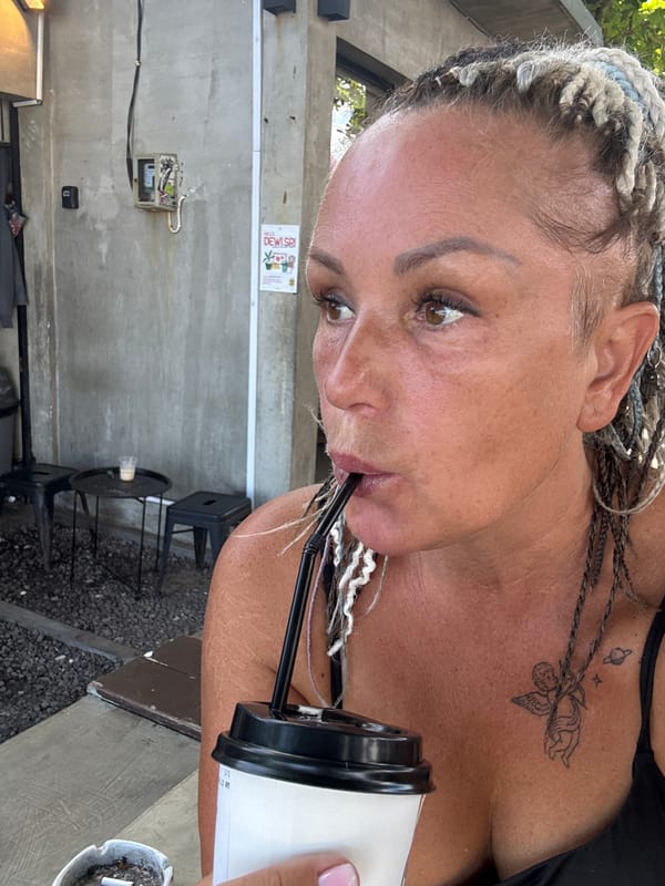 Woman drinks lemon tea on Kuta street early morning