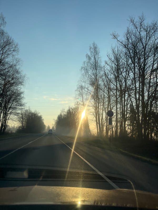 Vehicle travels road during sunrise in Opalevo, Russia