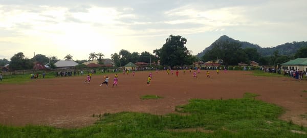 Afternoon football match on a dirt field in Mararaba, Nigeria