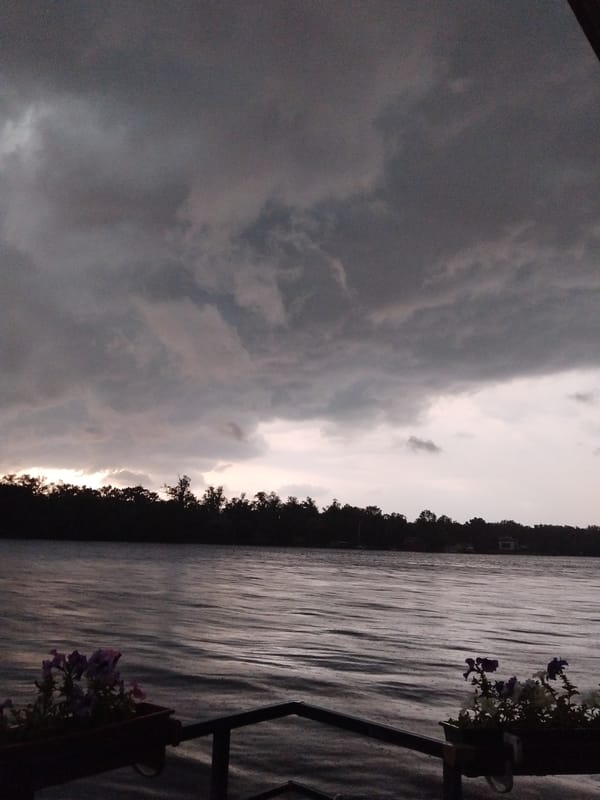 Storm rolls over the Dnipro, watched from a riverside deck